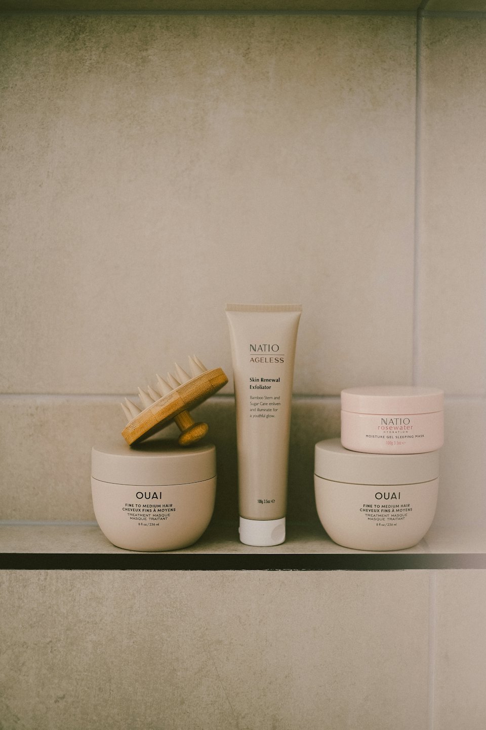 Skincare creams and a bamboo brush displayed on a shelf.
